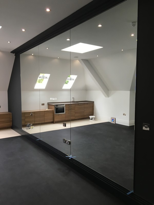 Frameless glass partition in loft conversion by Watford glaziers