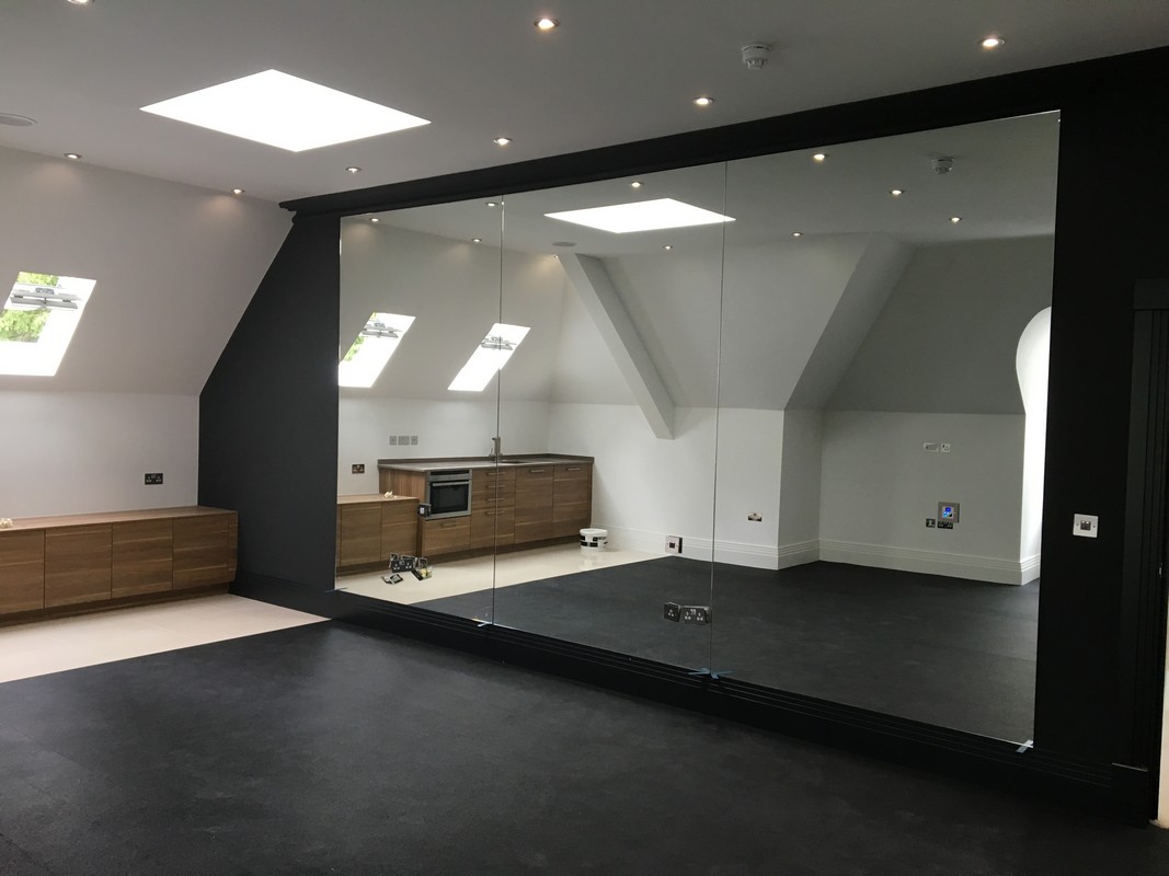 Frameless glass wall dividing loft conversion in Watford